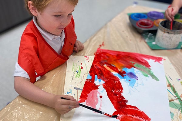 Young student painting in art class.