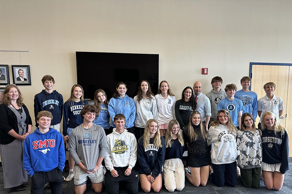 Former St. Mary's students wearing their college sweatshirts.