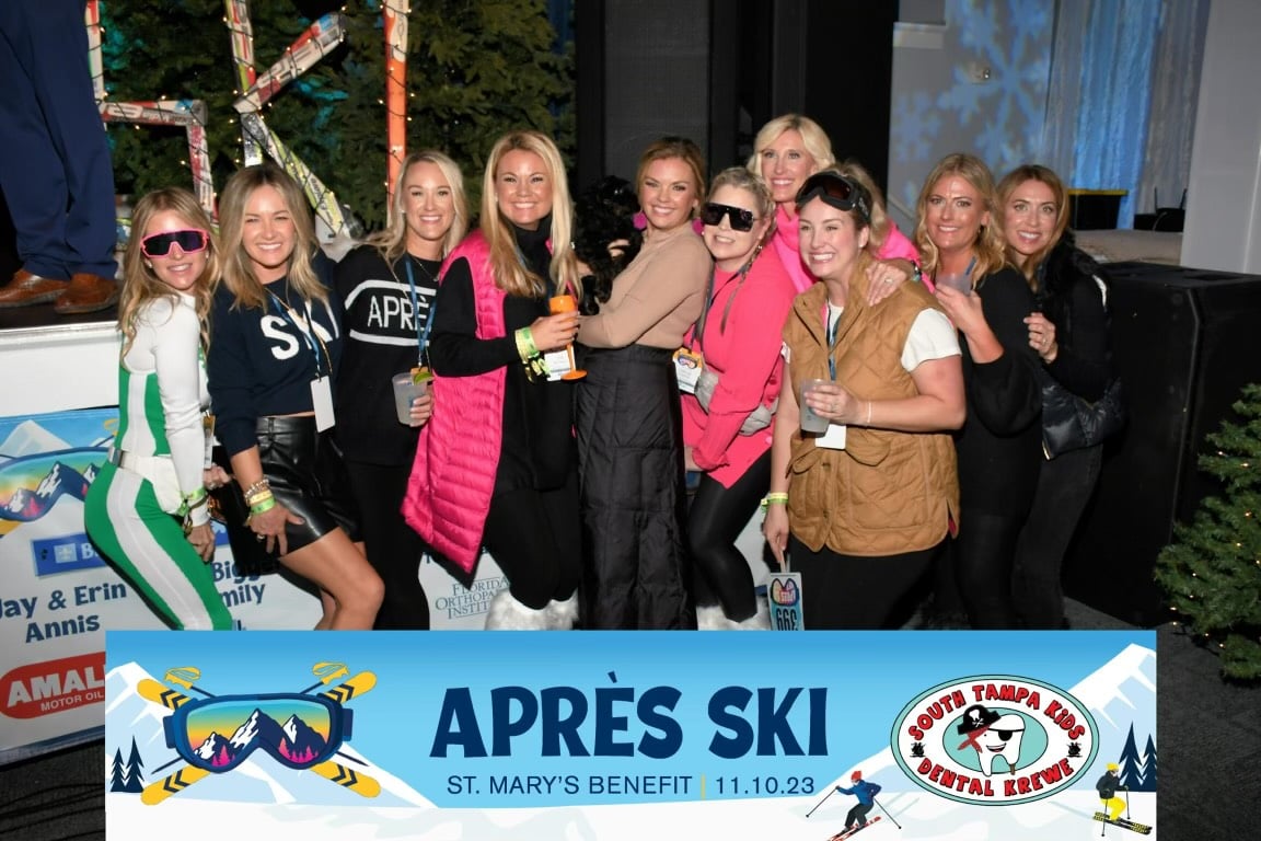 A group of people standing behind a banner saying Après Ski. St. Mary's benefit.