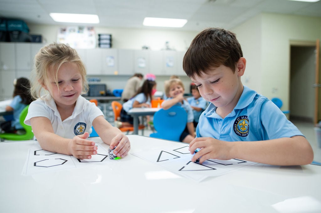 Two students tracing shapes.