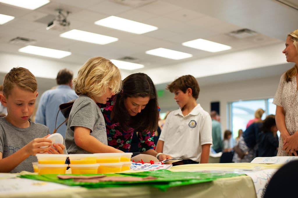 Children working on an art project with their teacher.