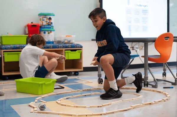 A student inside a a circle of building blocks during an activity.